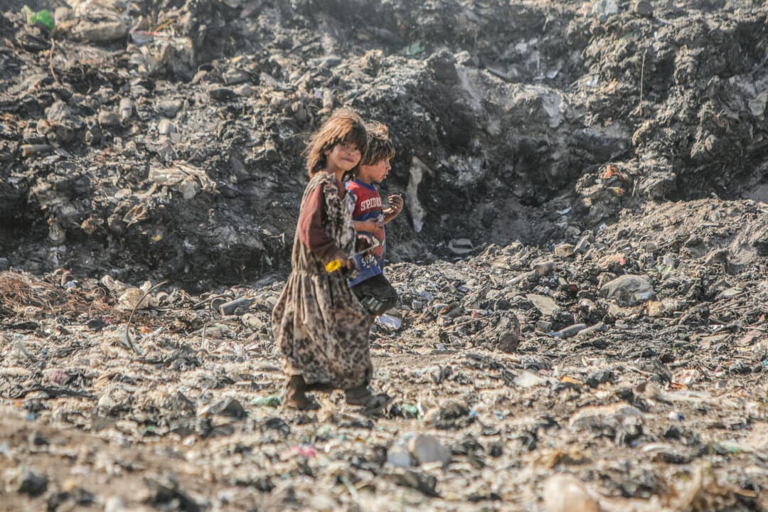 Displaced Syrian children walk through rubbish at a dump near the village of Nu'man, north of Aleppo, Syria, on Sept. 16, 2026. Displaced families rely on scavenging for recyclable plastic and metal. (Bakr Alkasem/AFP via Getty Images)