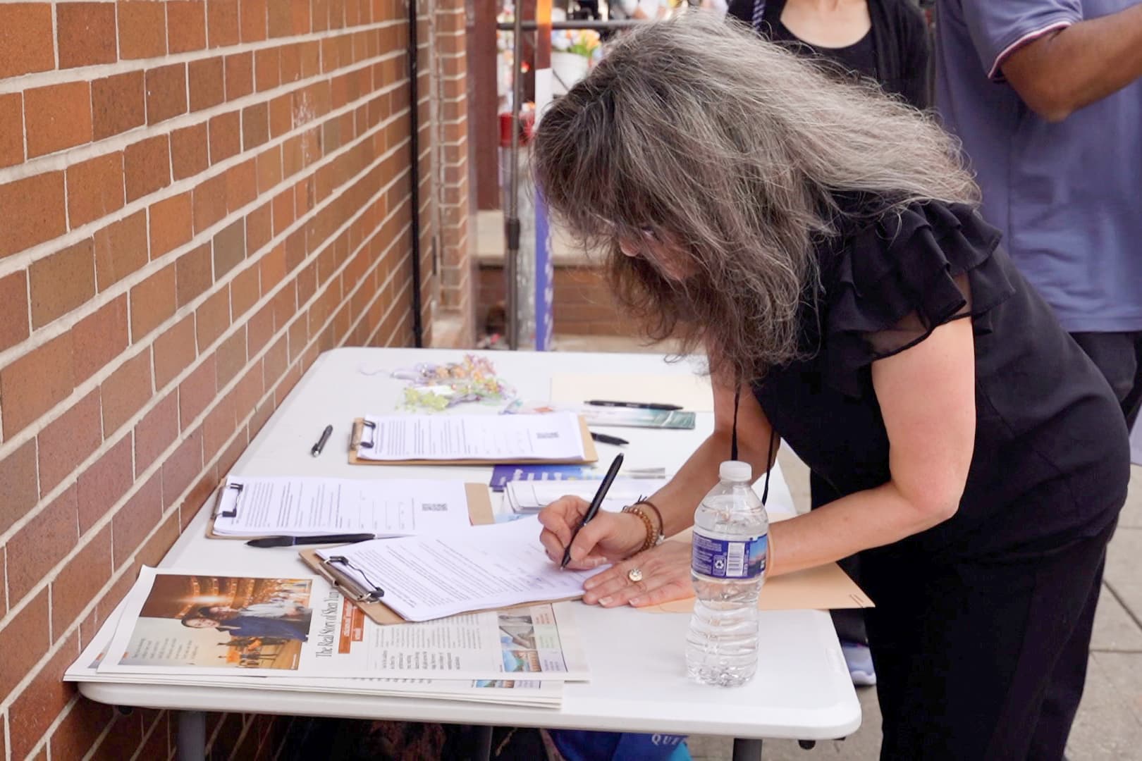 Christine Flowers, a Philadelphia immigration lawyer and syndicated columnist, signed a petition supporting Falun Gong and victims of forced organ harvesting protection bill at a rally in Philadelphia on Sept. 19, 2026. (Steve Wen/The Epoch Times)