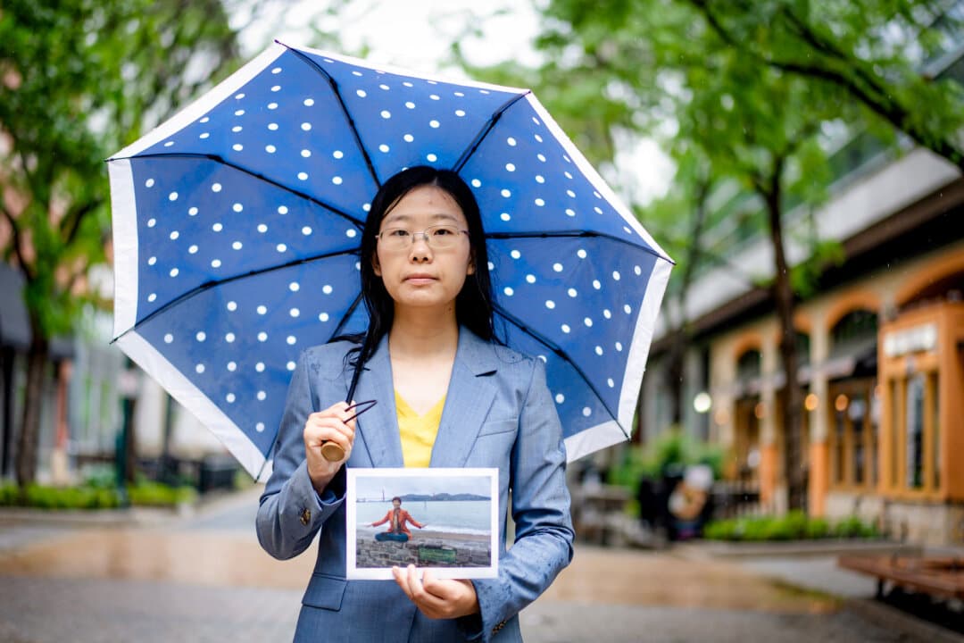 Alisa Zhou holds a photo of her mother, Wang Youmei, in Rockville, Md., on May 6, 2026. Wang was arrested in China in April 2026 for practicing Falun Gong. (Madalina Kilroy/The Epoch Times)