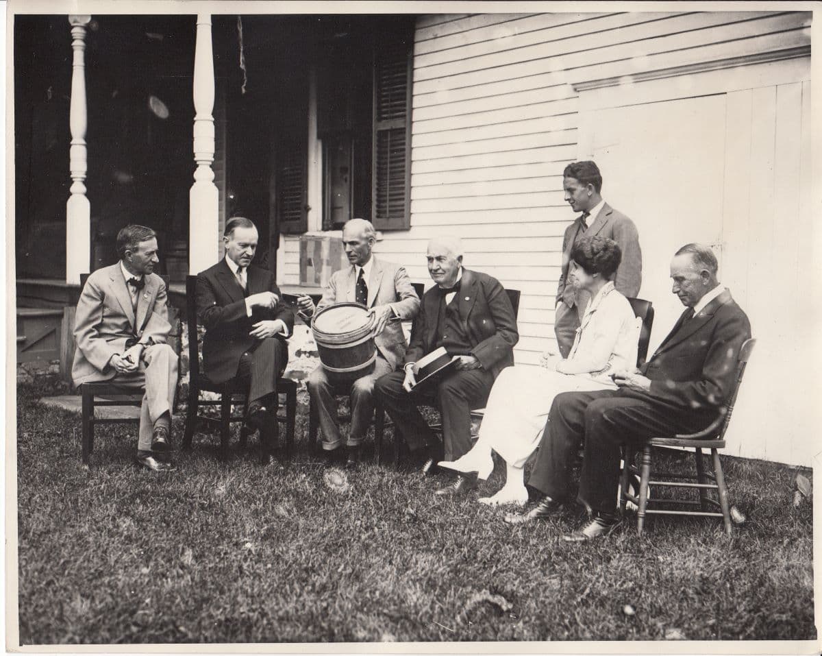 Harvey Firestone Sr. (L) visited President Calvin Coolidge (2nd L) and his family at his farm. A young Russell Firestone (standing) was also in attendance. National Park Service. (Public Domain)