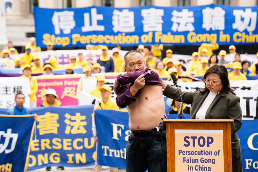 Cheng Peiming, a Falun Gong practitioner who had his organs forcibly removed in China, shows his scars at a rally to demand an end to the Chinese Communist Party's persecution of Falun Gong, during Chinese leader Xi Jinping's state visit to Washington on Sept. 24, 2026. (Samira Bouaou/The Epoch Times)