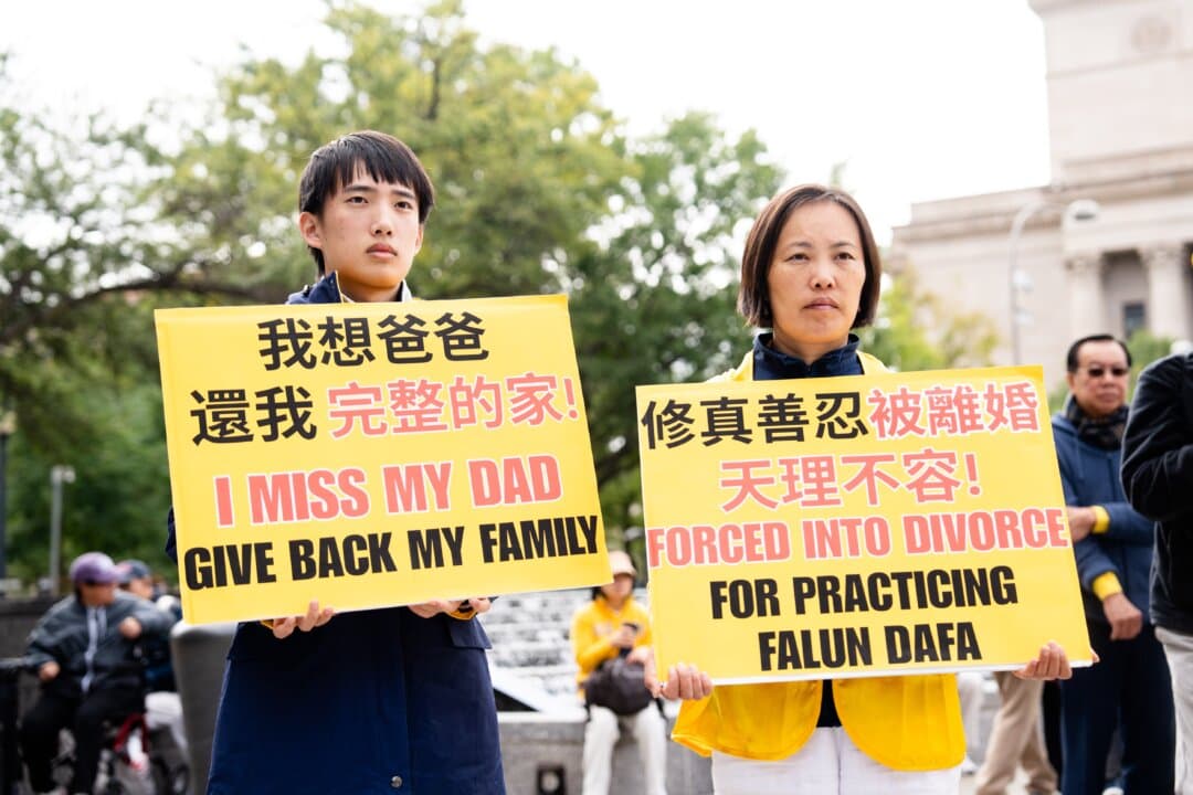 Fei Feng Lou, whose husband was forced to divorce her in China, and her son Runxin Wang hold signs at a rally held by Falun Gong practitioners to demand an end to the Chinese Communist Party's persecution of the spiritual practice, during Chinese leader Xi Jinping's state visit to Washington on Sept. 24, 2026. (Samira Bouaou/The Epoch Times)