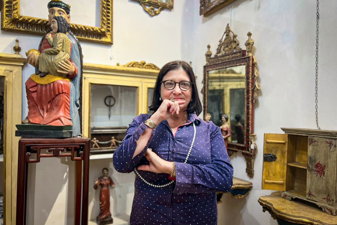 Giuliana Grillotti, an art historian, stands among works displayed at AMart Firenze, the artisan workshop and boutique featuring antiques and reproductions that she runs with her husband, in Florence, Italy, on Sept. 26, 2026. (Beige Luciano-Adams/The Epoch Times)