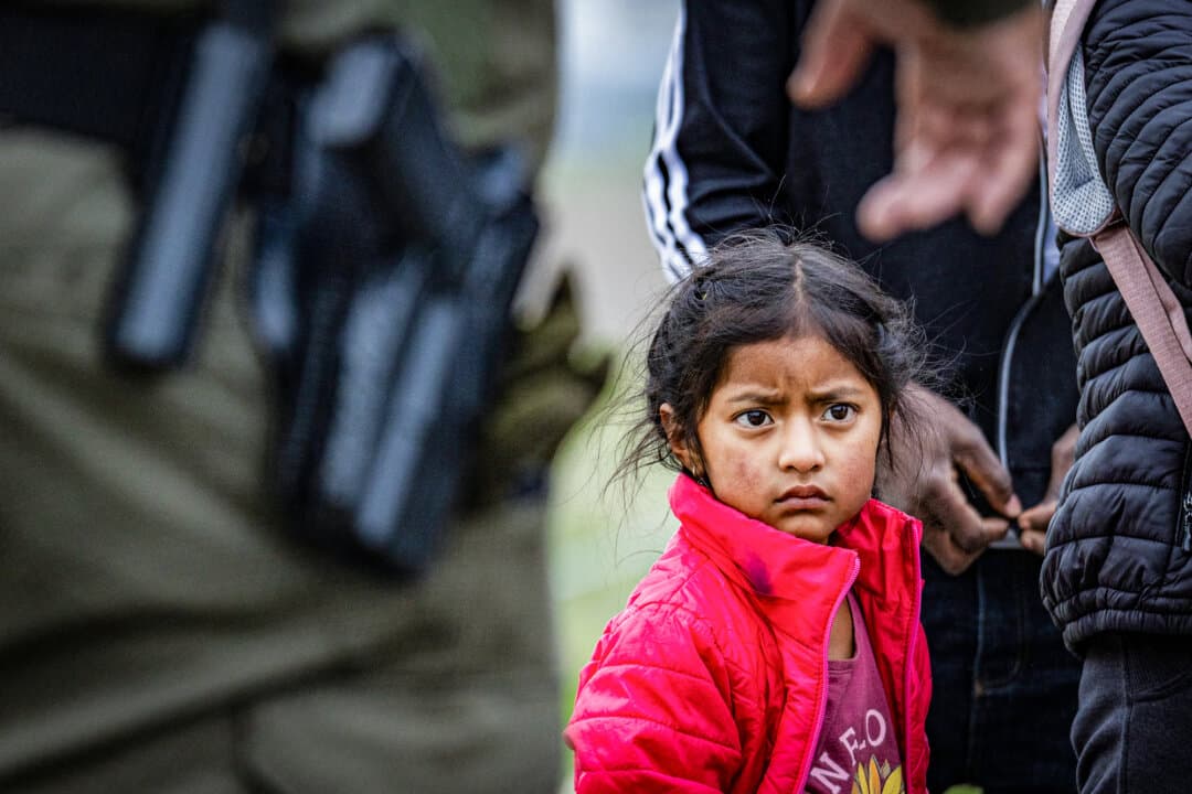 An illegal immigrant child awaits processing by Border Patrol agents in the Otay Mesa neighborhood of San Diego on Feb. 29, 2024. (John Fredricks/The Epoch Times)