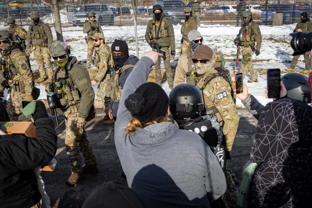 Protesters face off with federal officers in front of the Bishop Henry Whipple Federal Building in Minneapolis on Jan. 9, 2026. (John Fredricks/The Epoch Times)