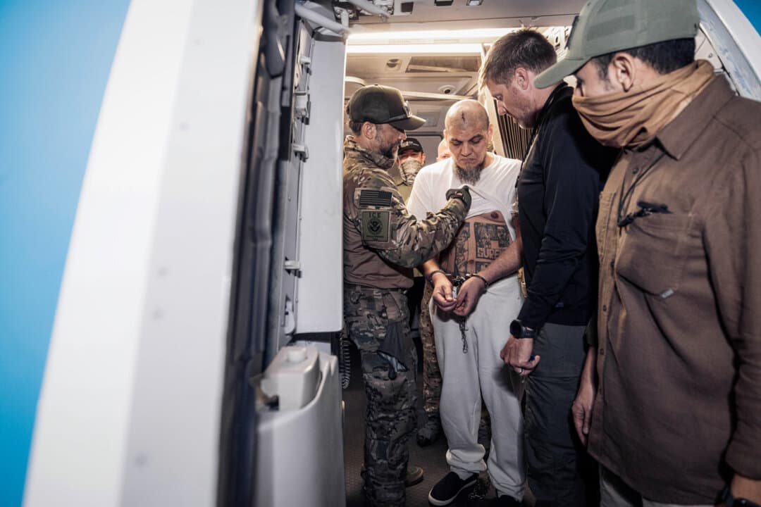 A member of U.S. Immigration and Customs Enforcement reviews tattoos on an inmate at CECOT, El Salvador's Terrorism Confinement Center, in Tecoluca, El Salvador, on March 16, 2025. Salvadoran President Nayib Bukele has housed members of Venezuelan criminal organizations deported by the Trump administration in the maximum-security mega-prison. (Salvadoran government via Getty Images)