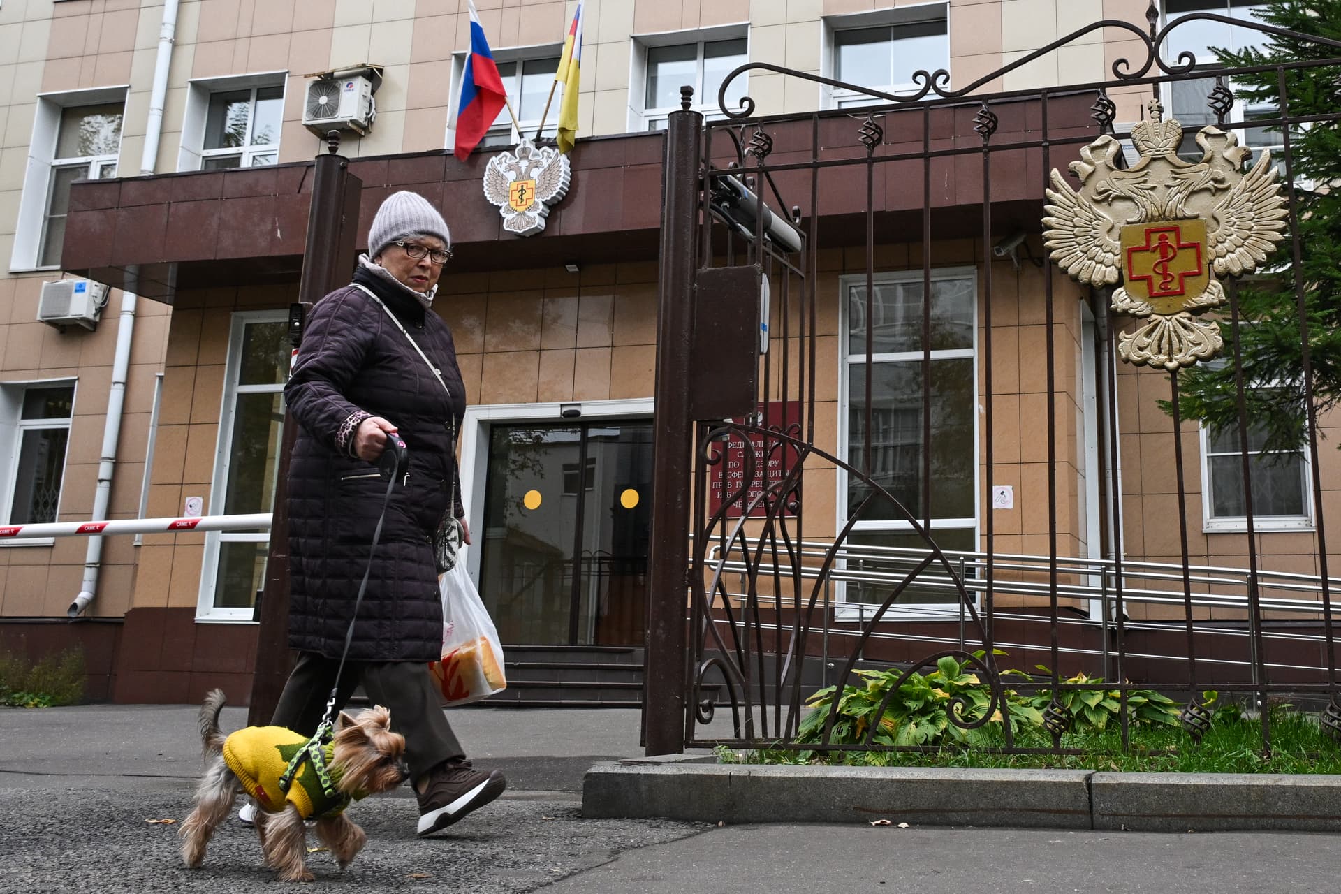 A woman walks a dog past the headquarters of Russia's consumer and health watchdog Rospotrebnadzor in Moscow on Oct. 5, 2026. (Igor Ivanko/AFP via Getty Images)