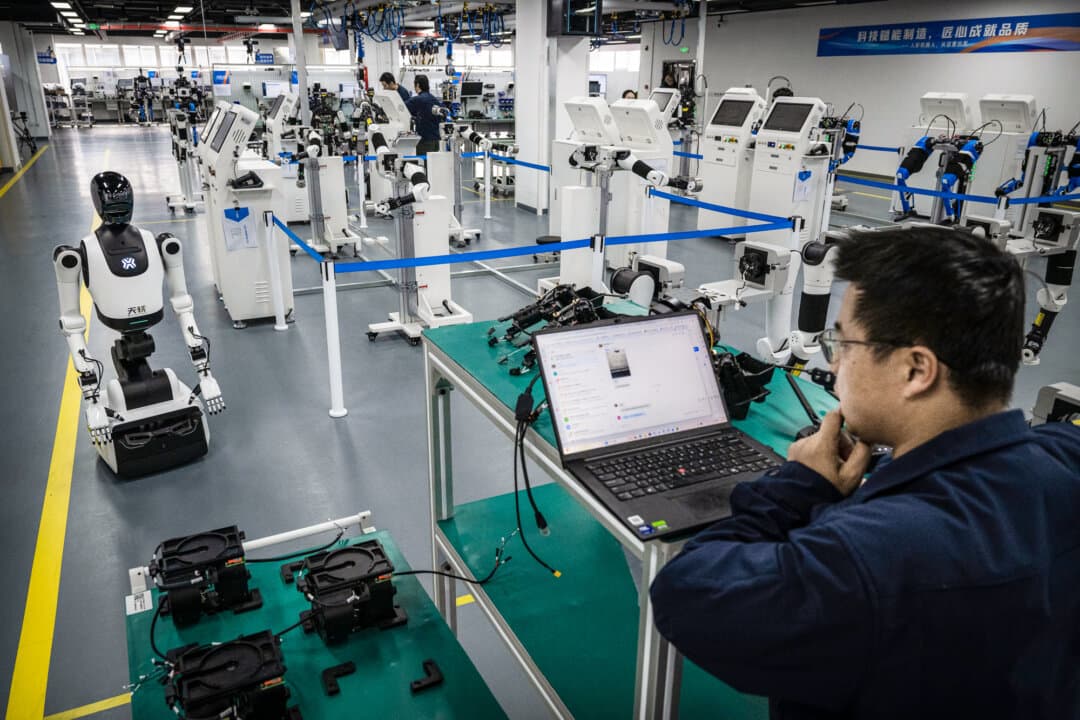 An engineer tests humanoid robots at the Beijing Humanoid Robot Innovation Center in Beijing on March 20, 2026. China is investing tens of billions of dollars to advance its humanoid robot sector. (Kevin Frayer/Getty Images)