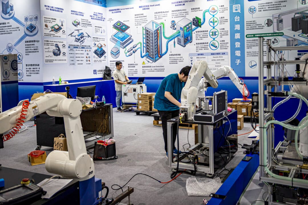 Engineers configure and test industrial robotic arms at a booth during preparation for COMPUTEX in Taipei, Taiwan, on June 1, 2026. One of the world's largest annual computer and technology trade shows, COMPUTEX showcases next-generation AI chips, robotics, and computing infrastructure. (Cheng Chia Huang/Getty Images)