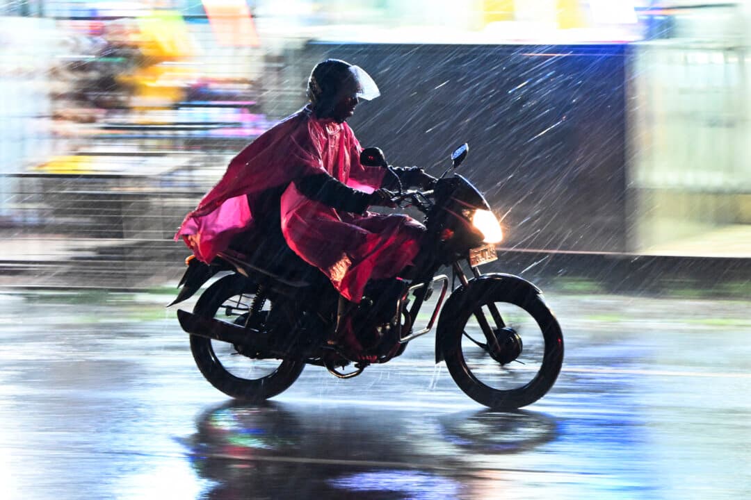 A motorcyclist rides along a street during a spell of heavy rain in Colombo, Sri Lanka, on Oct. 6, 2026. (Ishara S. Kodikara/AFP via Getty Images)