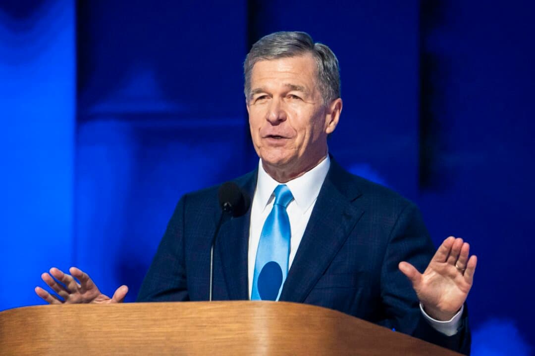 (Left) Then-Republican National Committee Chairperson Michael Whatley speaks following the inauguration of President Donald Trump during an event at Capital One Arena in Washington on Jan. 20, 2025. (Right) Then-North Carolina Gov. Roy Cooper speaks during the Democratic National Convention in Chicago on Aug. 22, 2024. (Madalina Vasiliu/The Epoch Times)