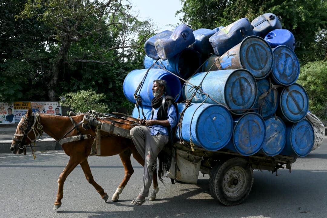 A man transports empty plastic drums on a horse-drawn cart on the outskirts of Amritsar, India, on Oct. 7, 2026. (Narinder Nanu/AFP via Getty Images)
