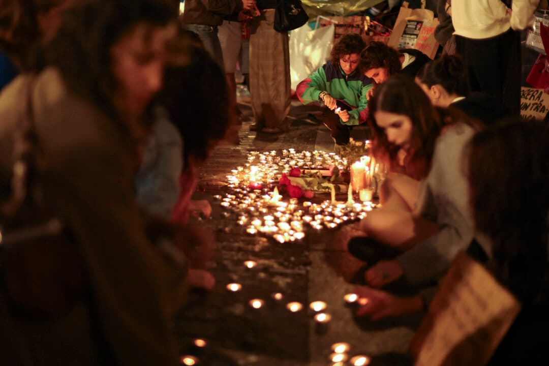 People gather for a vigil in Puerta del Sol, Madrid, after learning that 87-year-old pensioner Maricarmen Abascal died in a Madrid hospital on Oct. 7, 2026. Abascal became a symbol of Spain’s housing crisis after being evicted from her lifelong home on a stretcher following a sharp rent increase. (Thomas Coex/AFP via Getty Images)