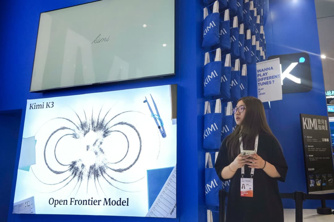 A worker stands at a booth for Chinese AI Startup Moonshot's Kimi K3 during the World AI Conference in Shanghai on July 17, 2026. China is trying to capture market share by offering free open-weight models, analysts say. (Ng Han Guan/AP Photo)