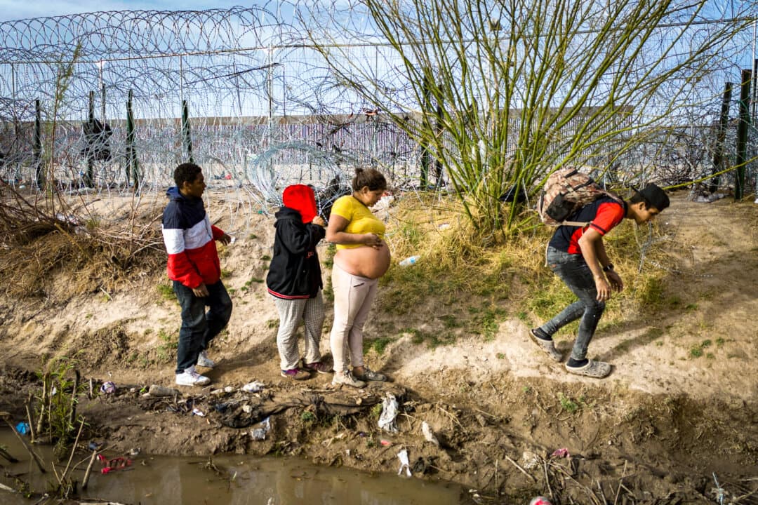 A pregnant woman from Venezuela walks with other illegal immigrants along the bank of the Rio Grande after crossing the U.S.–Mexico border in El Paso, Texas, on March 13, 2024. The DOJ launched a Birth Tourism Prevention Task Force in August after the Supreme Court on June 30 rejected President Donald Trump’s executive order on birthright citizenship that would have prevented children of illegal immigrants and legal temporary visitors from obtaining U.S. citizenship at birth. (John Moore/Getty Images)