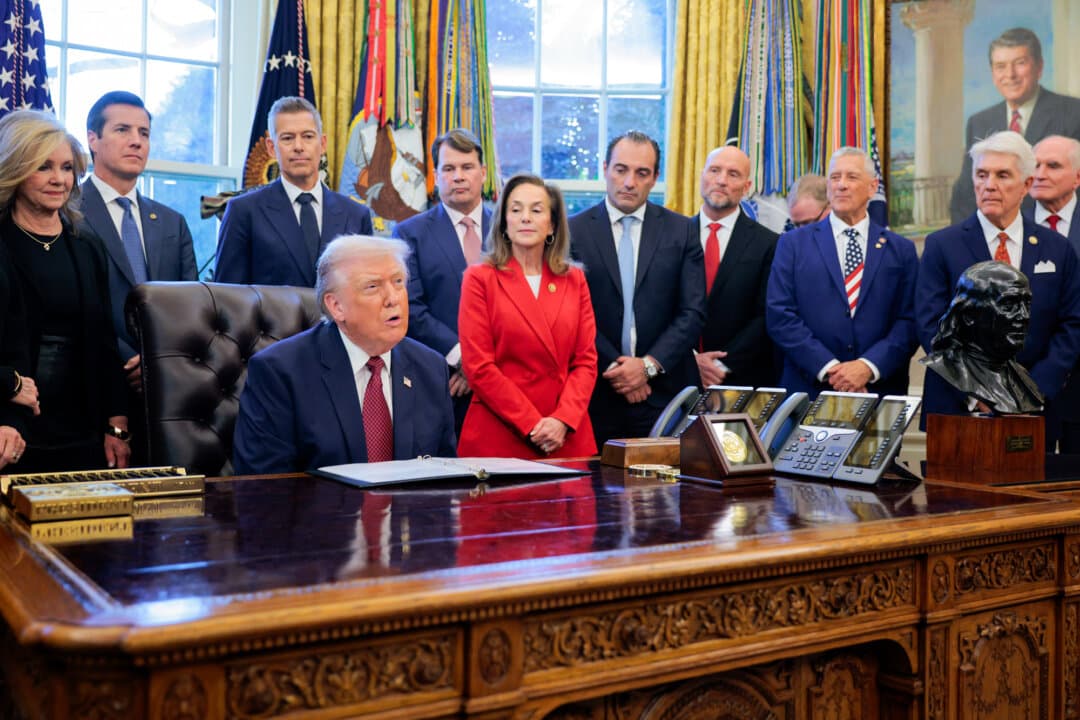 Joined by executives from major automakers, U.S. President Donald Trump makes an announcement about changes to U.S. fuel economy standards, in the Oval Office on Dec. 3, 2025. Trump relaxed fuel efficiency standards as part of his agenda to lower the price of gasoline-powered cars and dismantle policies that promoted electric vehicles. (Chip Somodevilla/Getty Images)