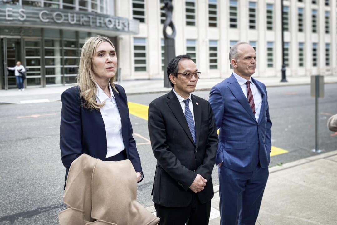 Attorneys Susan Carman (L) and John Carman (R) speak to reporters with client Lu Jianwang outside the federal courthouse for the Eastern District of New York in Brooklyn on May 13, 2026. Jianwang was found guilty of acting as an unregistered agent of the Chinese government; prosecutors alleged that he operated a secret police station on behalf of Beijing in Manhattan's Chinatown neighborhood. (Nicholas Zifcak/ The Epoch Times)