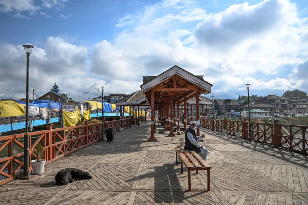 An elderly man sits on a bench along a foot bridge in Srinagar, India, on Oct. 15, 2026. (Tauseef Mustafa/AFP via Getty Images)