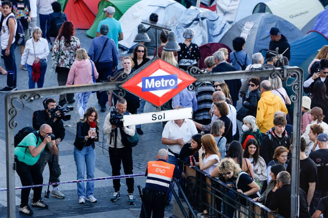 A Madrid Metro security guard cordons off the entrance to the Puerta del Sol station in Madrid on Oct. 16, 2026. Officials announced the station's closure over health concerns as protesters continue their encampment calling for housing reform after the eviction of Maricarmen Abascal, 87, from her longtime apartment on Sept. 23 and her subsequent death in a hospital. (Oscar del Pozo/AFP via Getty Images)