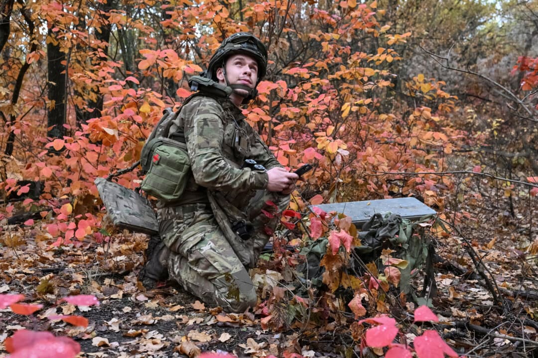 An artilleryman with the Special Rifle Police Battalion of Ukraine's Zaporizhzhia Oblast region sets up a Starlink satellite internet system at a position near the front line in Donetsk region, Ukraine, on Oct. 16, 2026. (STR/Reuters)