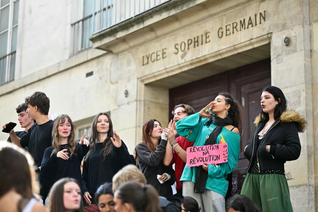 Students sing during a protest outside Sophie-Germain High School in Paris on Oct. 16, 2026, as part of a nationwide student mobilization over learning conditions. (Lou Benoist/AFP via Getty Images)