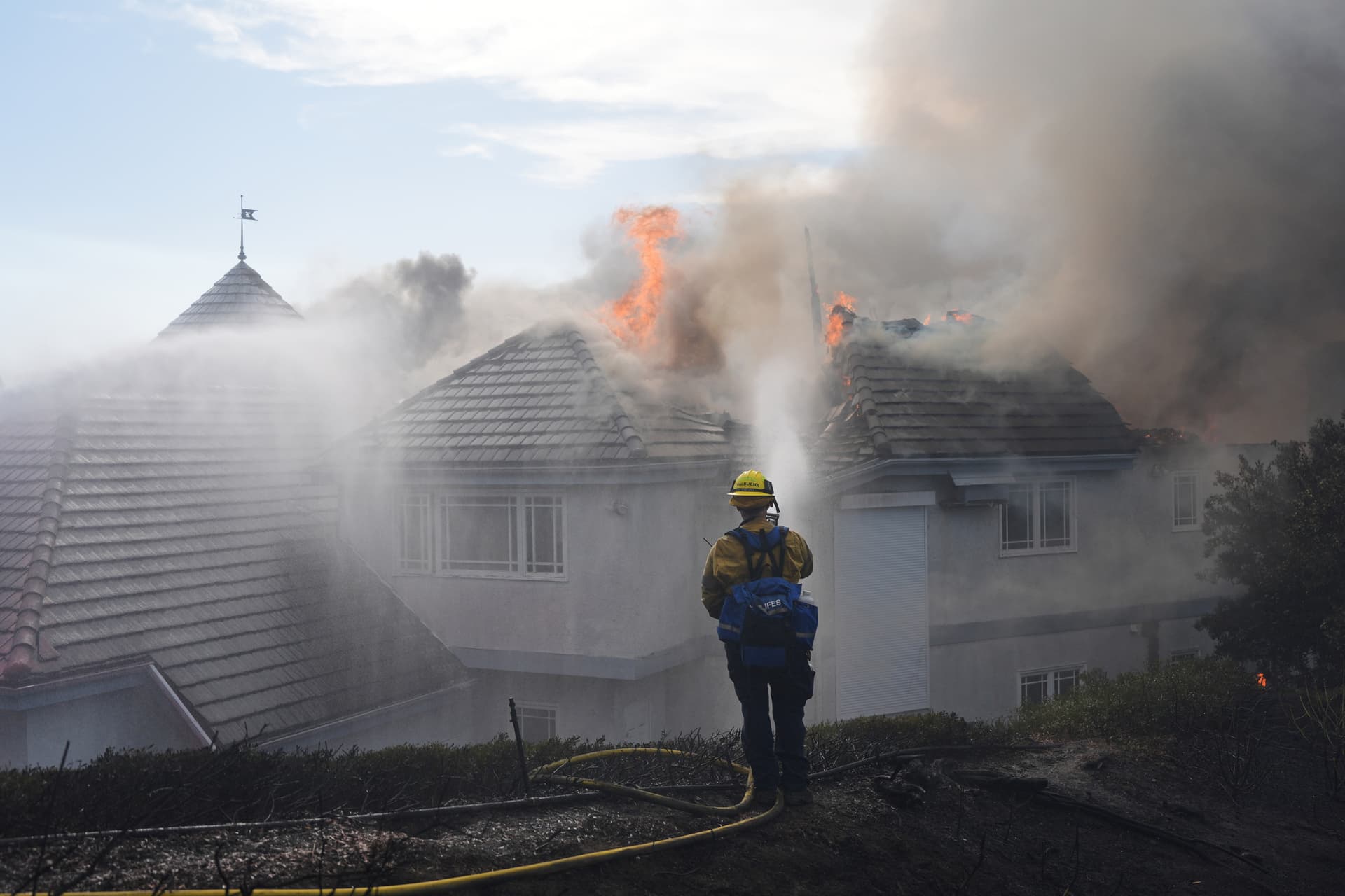 A firefighter works to douse a fire on the roof of a house engulfed in flames during the Norte Fire in San Juan Capistrano, Calif., on Oct. 16, 2026. (Jae C. Hong/AP Photo)