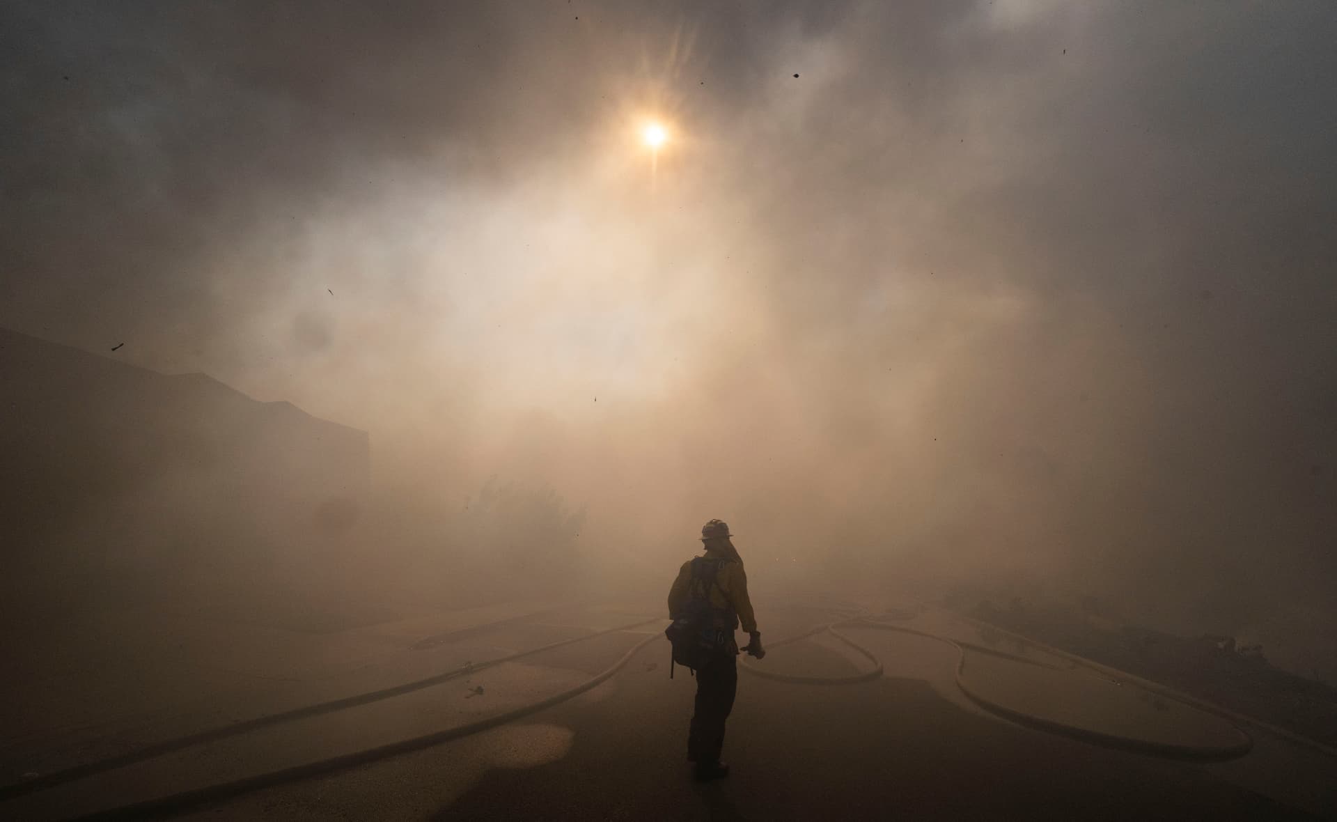 The sun is obscured by smoke as firefighters work to save structures on Via La Mirada during the Norte fire in San Clemente, Calif., on Oct. 16, 2026. (Paul Bersebach/The Orange County Register via AP)