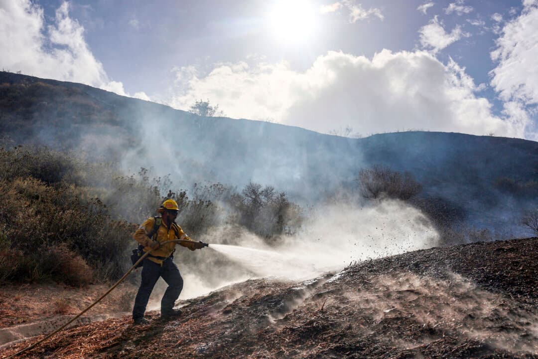A firefighter with Los Angeles County Fire tackles the Bike wildfire in the outskirts of Santa Clarita, Calif., after it started on Oct. 11, 2026. The wire, which started that afternoon, grew rapidly but was successfully contained later that evening. (David Swanson/AFP via Getty Images)