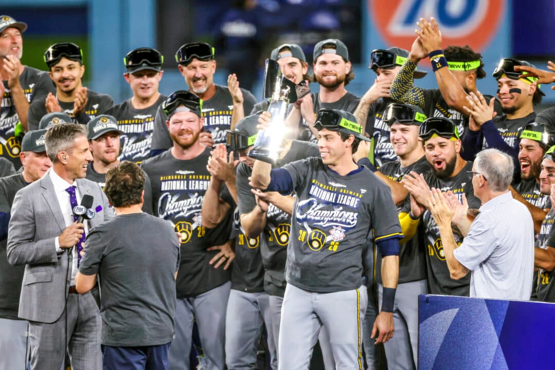 Christian Yelich (22) of the Milwaukee Brewers celebrates with the Warren C. Giles Trophy after defeating the Los Angeles Dodgers in game four of the National League Championship Series at Dodger Stadium in Los Angeles on Oct. 15, 2026. (Luke Hales/Getty Images)