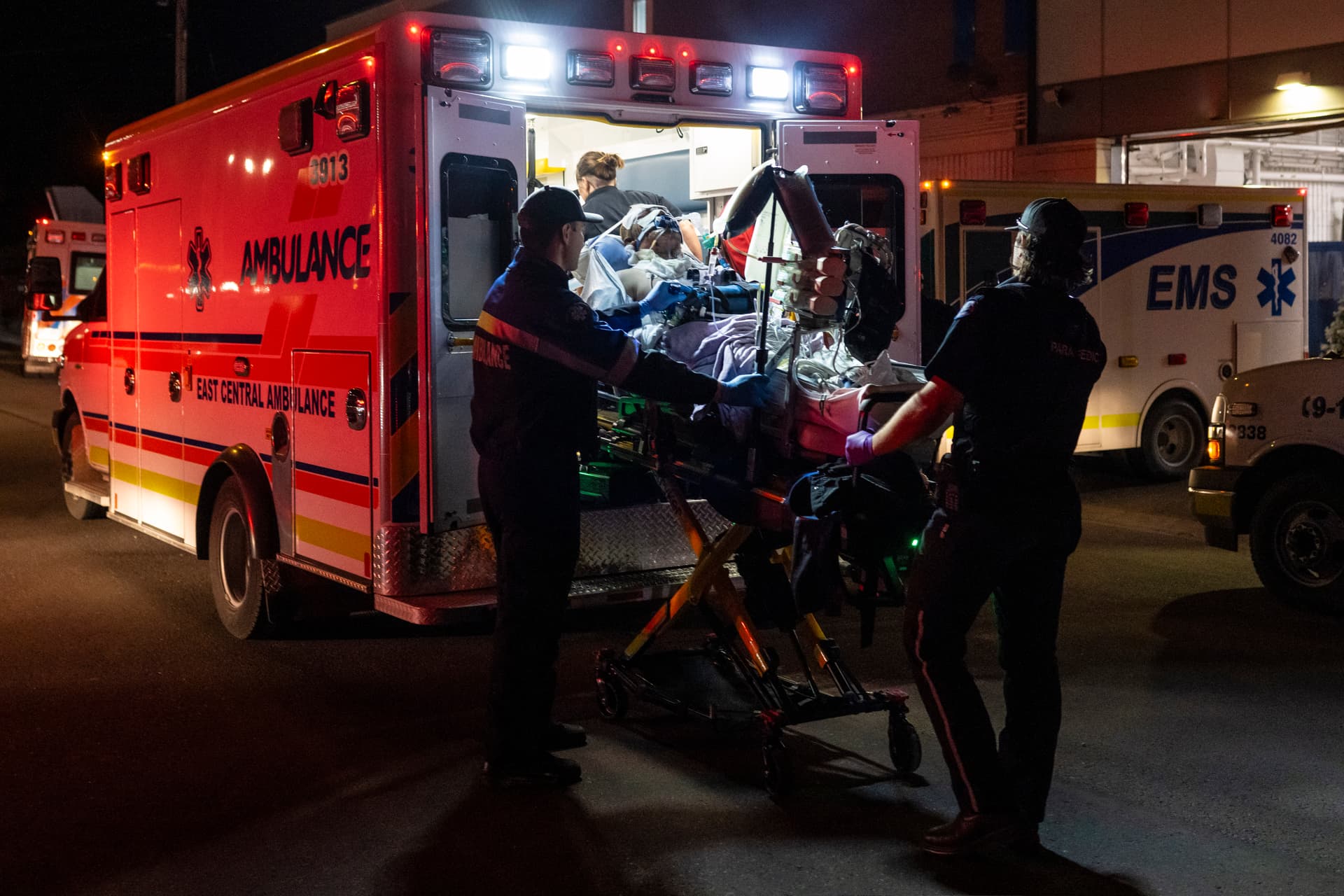 Paramedics load an injured person into an ambulance at the Wainwright Health Centre as injured military members are treated after a fire at CFB Wainwright, outside of Wainwright, Alta., on Oct. 17, 2026. (The Canadian Press/John Ulan)