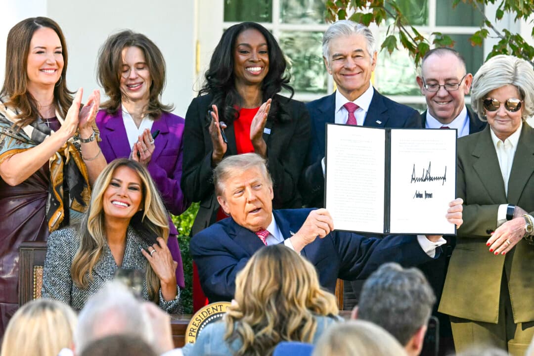 President Donald Trump, alongside First Lady Melania Trump, holds an executive order to create a White House Women's Health Task Force during a signing ceremony in the Rose Garden of the White House in Washington on Oct. 19, 2026. (Jim Watson/AFP via Getty Images)