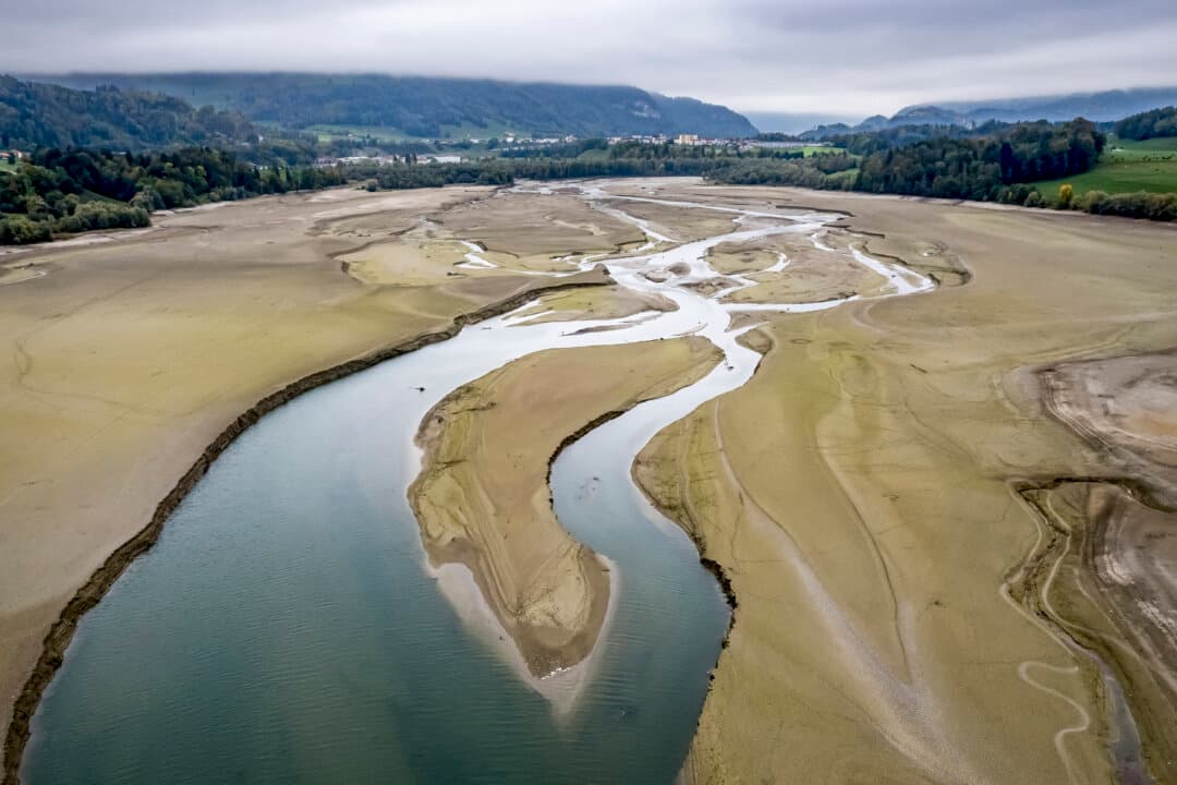 The exposed bed of the upper part of Lake Gruyere near Morlon, Switzerland, on Oct. 19, 2026, after water levels in the reservoir were temporarily lowered for maintenance work on infrastructure associated with the dam. (Fabrice Coffrini/AFP via Getty Images)