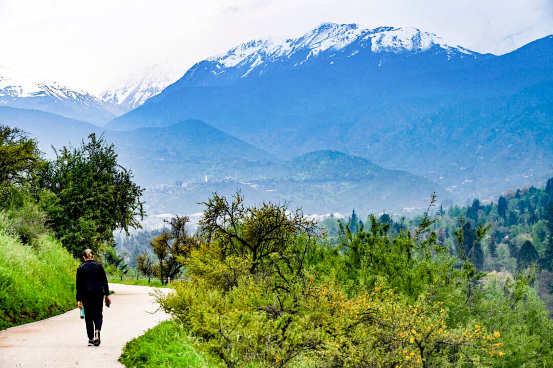 A woman walks along a path overlooking the snow-capped Andes mountain range in Santiago, Chile, on Oct. 19, 2026, ahead of forecast rainfall and hail. (Rodrigo Arangua/AFP via Getty Images)