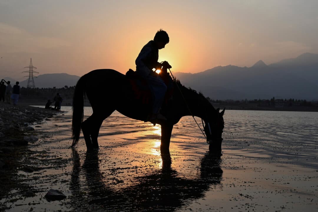 An Afghan boy sits on his horse as it drinks water from the Qargha Lake on the outskirts of Kabul, Afghanistan, on Oct. 19, 2026. (Wakil Kohsar/AFP via Getty Images)