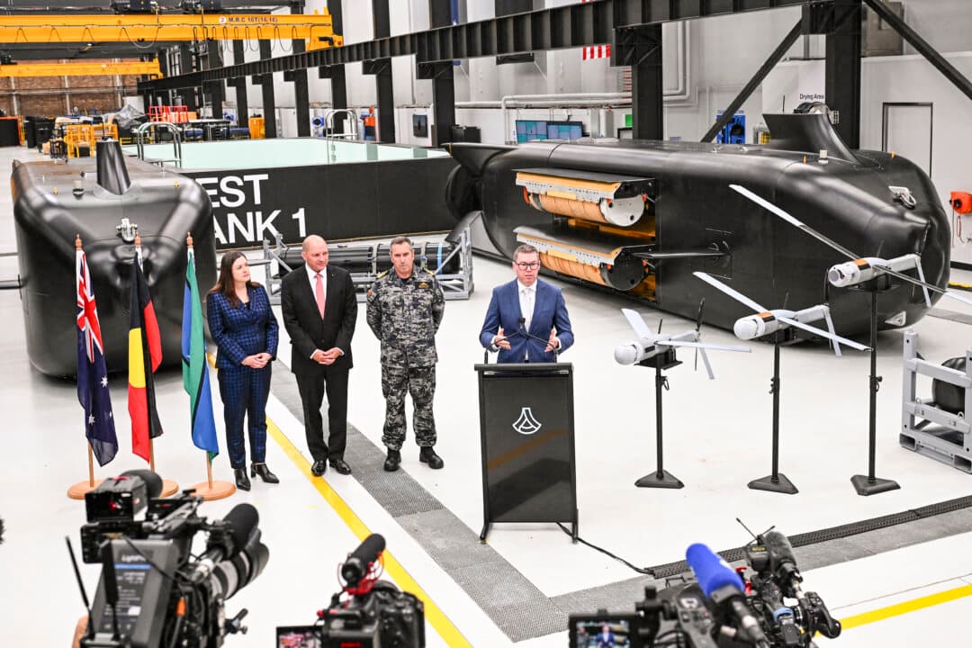Australia's Minister for Defence Industry Pat Conroy (R) speaks to the media alongside Australia's Chief Defence Scientist Tanya Monro (L), Anduril Australia & Asia Pacific CEO and Executive Chairman David Goodrich (2nd L), and Royal Australian Navy Chief of Navy Vice Admiral Matthew Buckley in front of the Ghost Shark autonomous undersea vehicles at an Anduril facility in Sydney, on Oct. 19, 2026. (Saeed Khan/AFP via Getty Images)