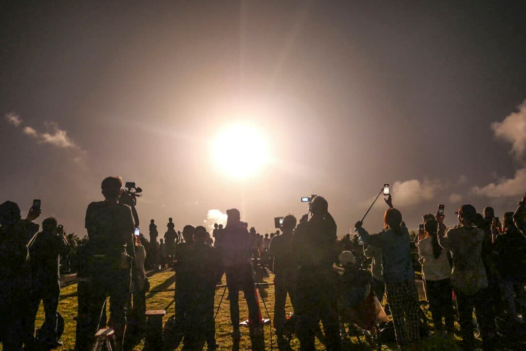 People watch the launch of the H3 rocket carrying Japan's Martian Moons eXploration (MMX) spacecraft from the Tanegashima Space Center in Kagoshima, Japan, on Oct. 20, 2026. The mission aims to collect samples from one of Mars’s moons to help scientists understand the origins of the Solar System. (Jiji Press/AFP via Getty Images)