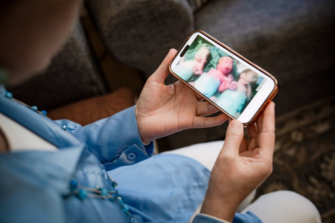 Mihrigul Tursun shows a photo of her triplets on her phone in Arlington, Va., on May 30, 2026. Tursun was detained after arriving in China with the infants in 2015. One of the triplets, Mohaned, died in a hospital in Xinjiang region while Tursun was in detention. (Madalina Kilroy/The Epoch Times)